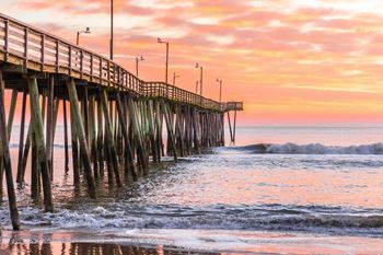 a pier with a sunset in the background at WaterFront Apartments, Virginia, 23453